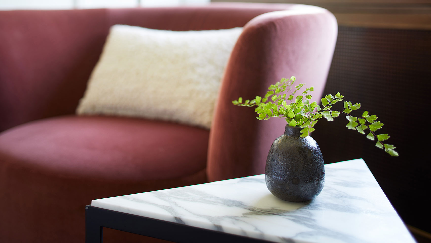 red plush chair with marble side table