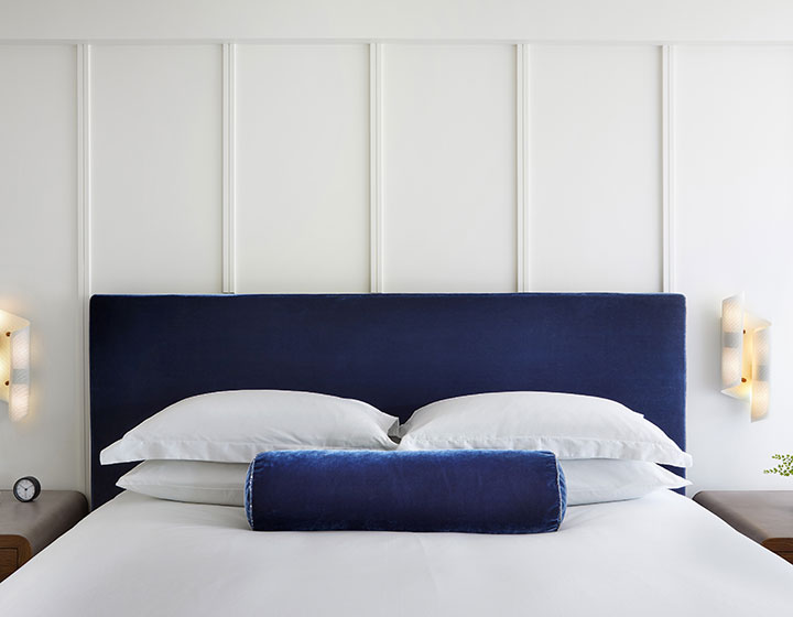 king bed with blue headboard guestroom