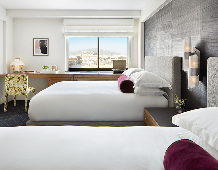 hotel guestroom with king bed and wooden desk work space